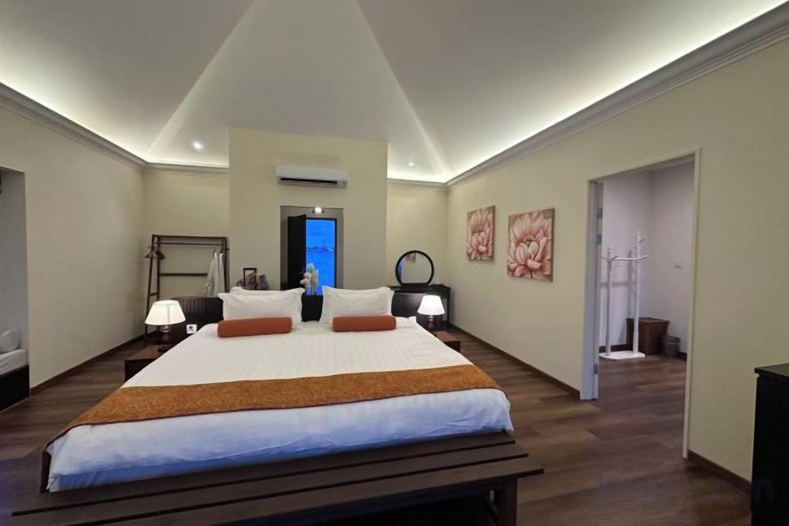 Une chambre d’hôtel avec un grand lit, des tables de chevet, un bureau et une chaise.