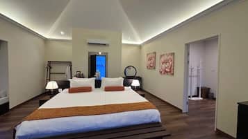 Une chambre d’hôtel avec un grand lit, des tables de chevet, un bureau et une chaise.