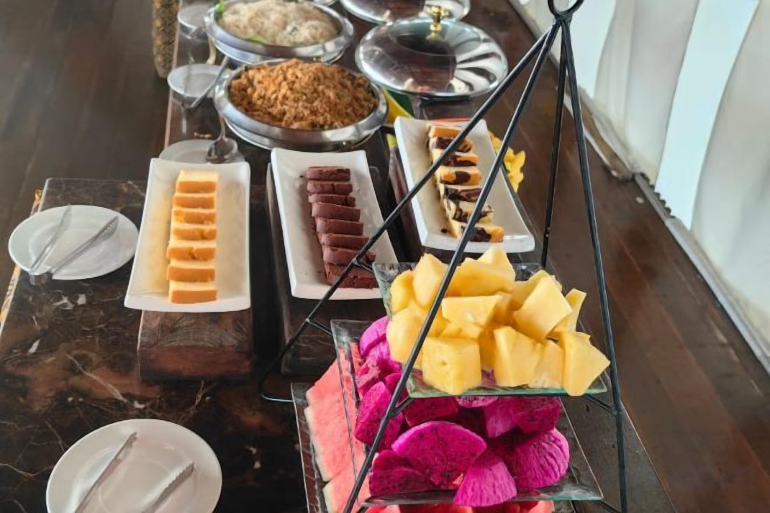 A buffet with various food items and a fruit display.