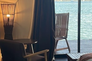 A room with a view of the sea, a wooden chair, a table, and a lamp. - Sea Star Resort Semporna (Semporna)