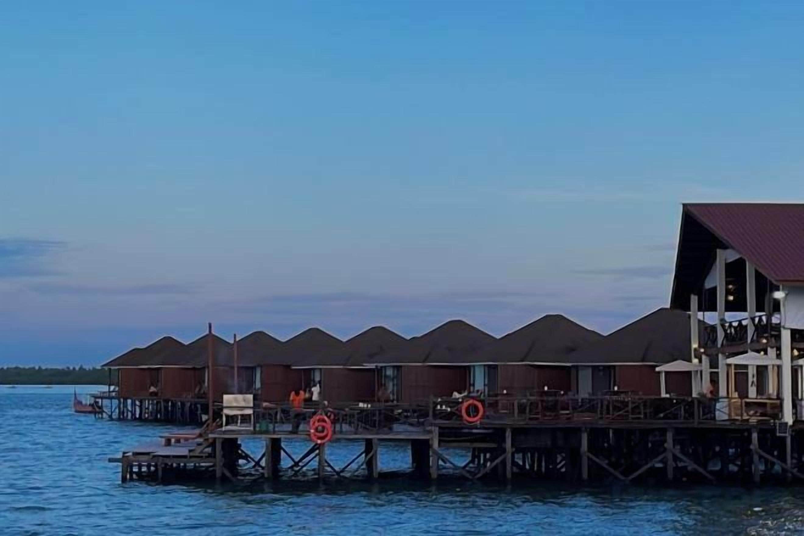 Bungalows over vandet med en træterrasse og en redningskrans.