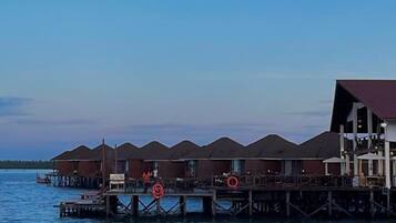 Bungalows over vandet med en træterrasse og en redningskrans.