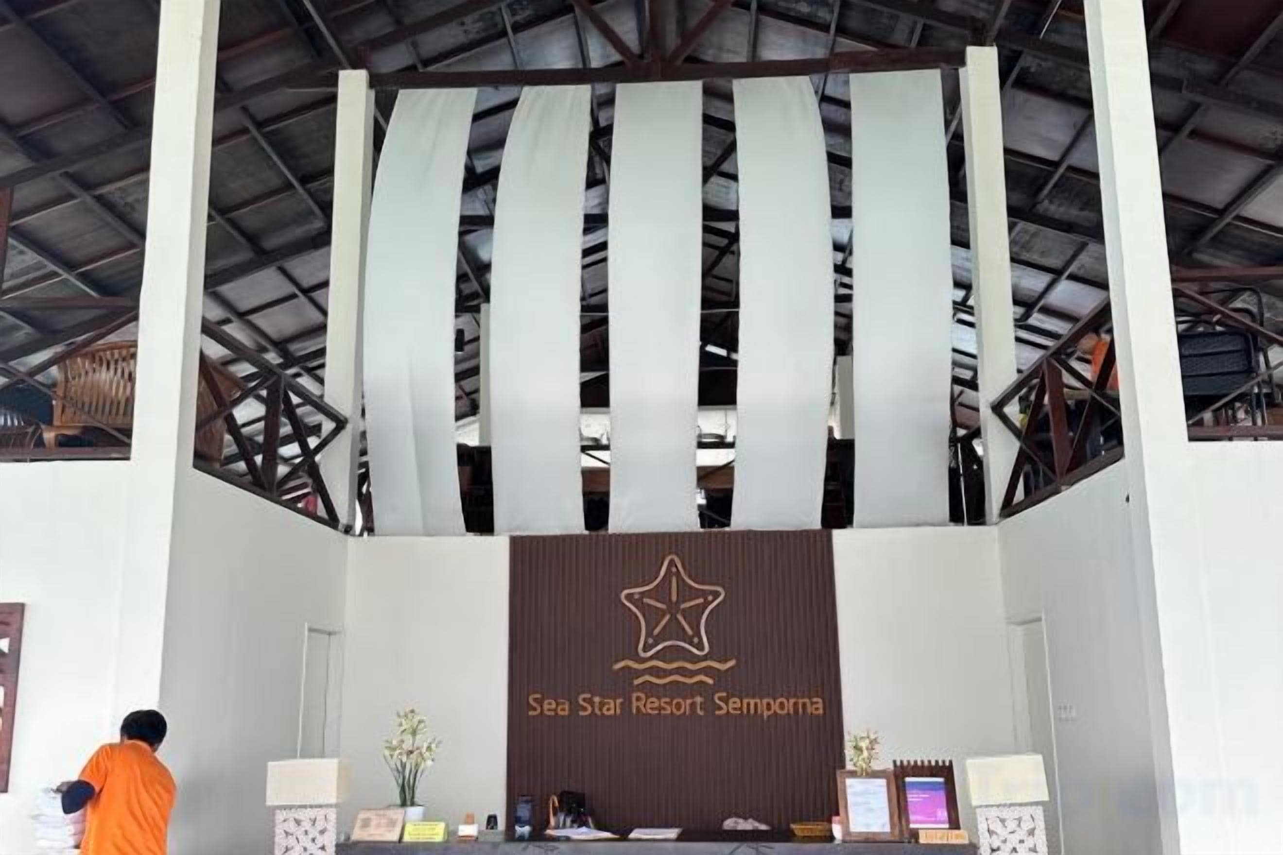 A reception area with a banner displaying the name 'Sea Star Resort Semporna.'