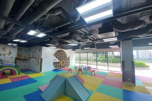 A play area with colorful mats, a slide, and a climbing structure.