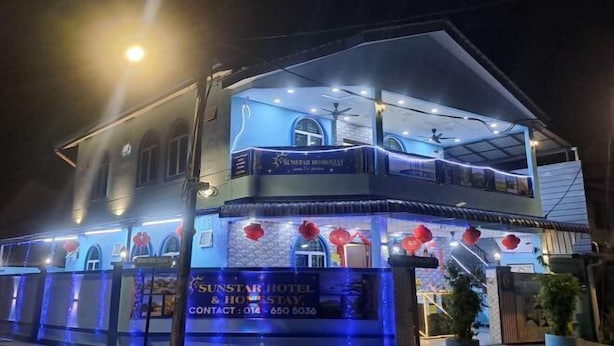 A two-story building with a sign for Sunstar Hotel & Holiday Stay. - Sunstar Hotel (Batu Maung)
