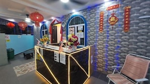 A reception area with a marble counter, red lanterns, and blue decorative lights. - Sunstar Hotel (Batu Maung)