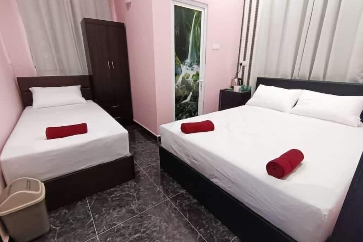 A hotel room with two beds, a wardrobe, a trash bin, and a door with a waterfall mural.