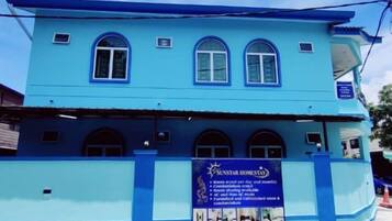 A two-story building with a blue facade and multiple windows.