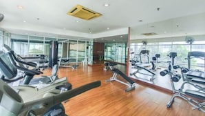 A gym with various exercise equipment, large windows, and a wooden floor. - MayTower by Horizon Homes (Kuala Lumpur)