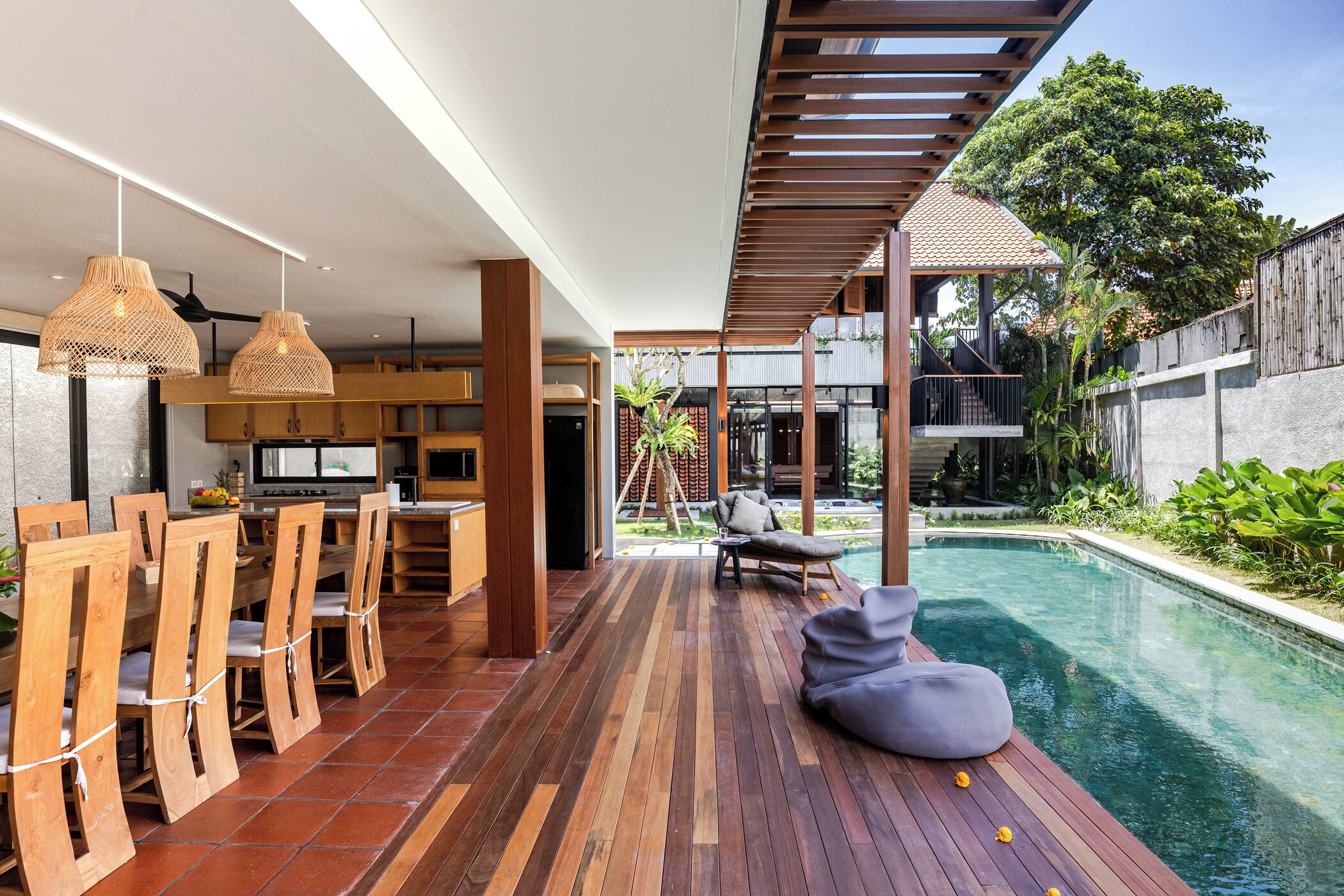 Eine moderne Küche mit Holzausstattung und einem Essbereich mit Blick auf den Pool.