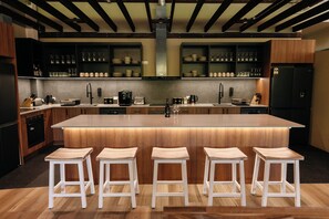 Une cuisine moderne dotée d’un îlot central, de tabourets de bar et d’une variété d’ustensiles de cuisine.