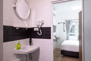 A bathroom with a white sink, a mirror, a telephone, and a shower. - Hoppers Mini (Bangkok)