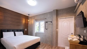 Une chambre à coucher avec un lit, une télévision, une porte et une fenêtre.