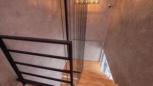 Un escalier avec des marches en bois et une rampe en métal noir.