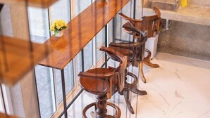 Une cuisine avec un comptoir-bar en bois, un évier et un vase rempli de fleurs.