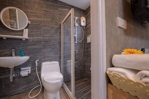 A modern bathroom with a glass-enclosed shower, a toilet, a sink, and a mirror. - Hoppers Mini (Bangkok)