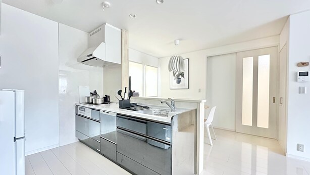 Eine moderne Küche mit Kochinsel, Edelstahlgeräten und minimalistischem Design.