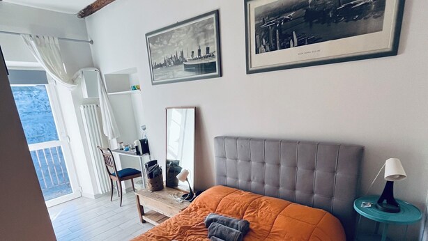 Ein Schlafzimmer mit einem großen Bett, einem Spiegel und zwei gerahmten Bildern an der Wand.