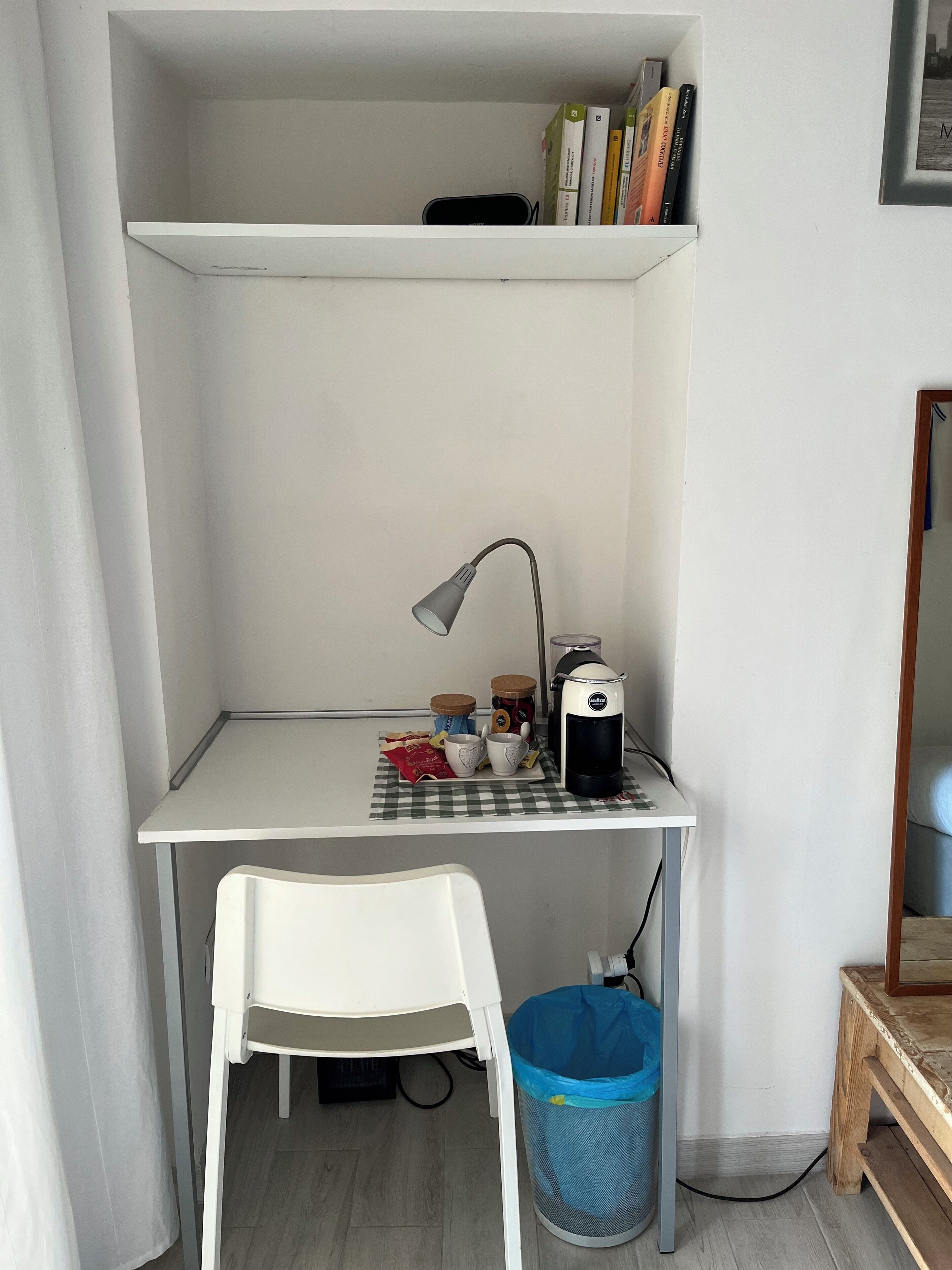 Un'area lavoro compatta con scrivania, sedia e macchina del caffè.