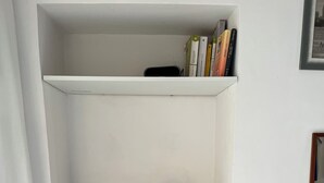 Ein kompakter Arbeitsbereich mit Schreibtisch, Stuhl und Kaffeemaschine.