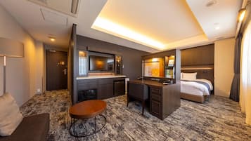 Ein Hotelzimmer mit Bett, Schreibtisch, Stuhl und kleinem Tisch.