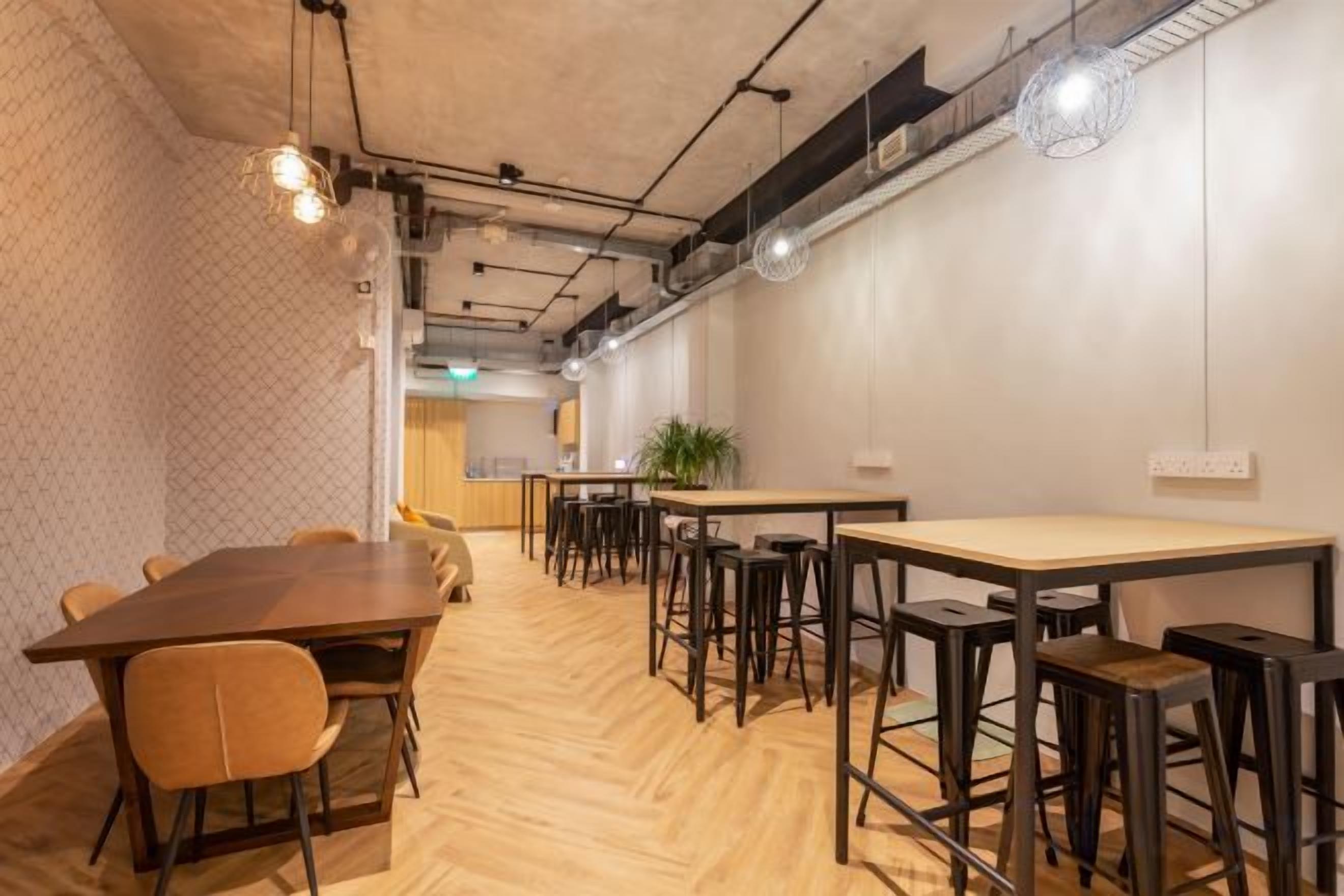 Una sala de conferencias con una larga mesa, varias sillas y una zona de bar con taburetes.