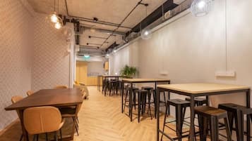 Una sala de conferencias con una larga mesa, varias sillas y una zona de bar con taburetes.