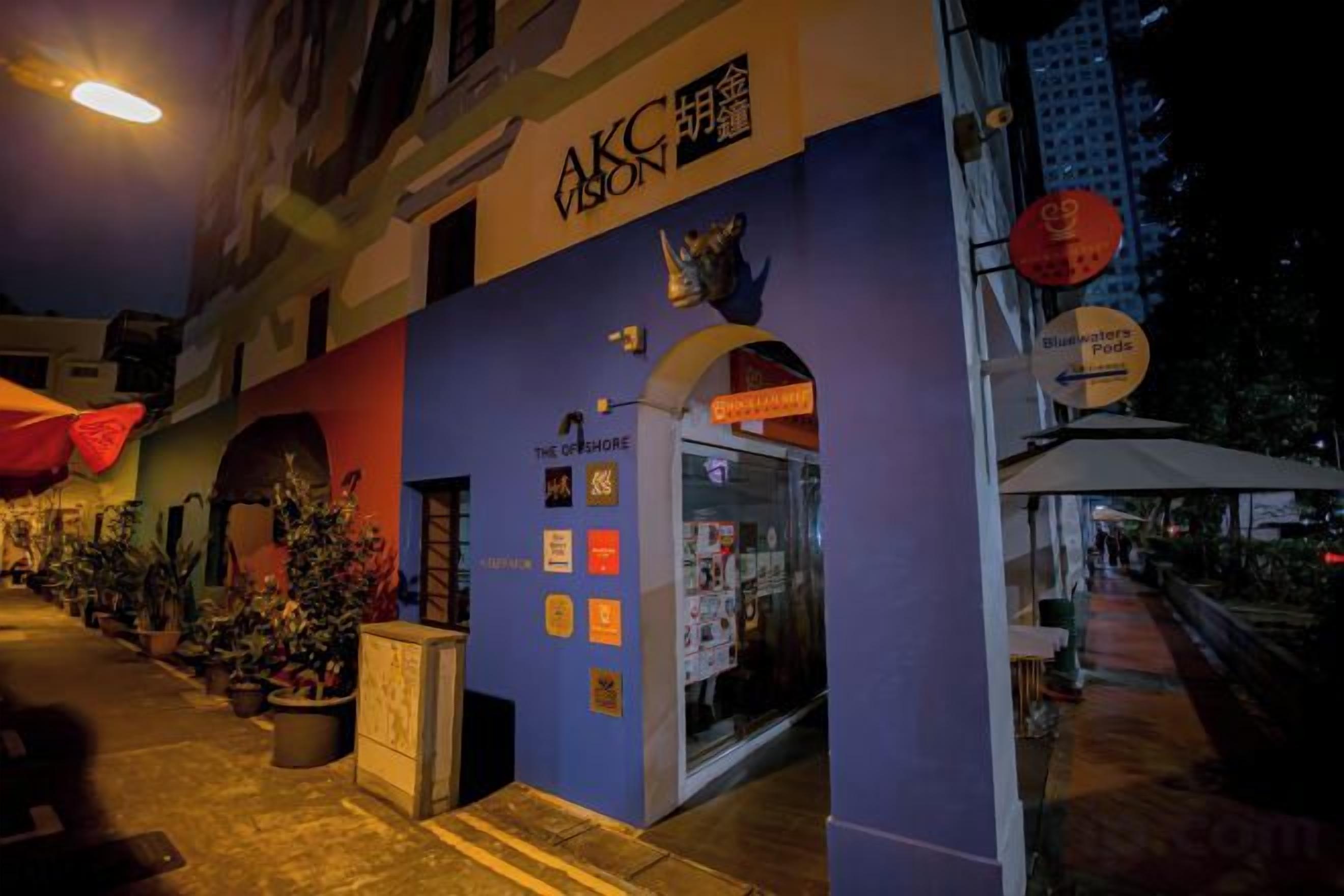 A building with a blue facade, a visible entrance, and a sign indicating a business or service area.