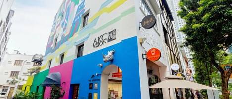 A colorful building with a restaurant on the ground floor, a visible entrance, and a sign indicating a business name.