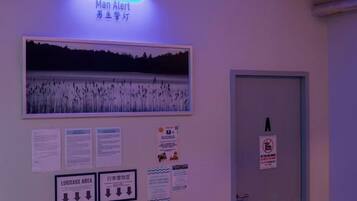 Una pared con un letrero que dice 'Man Alert' y una puerta con un letrero que indica zona de equipaje.