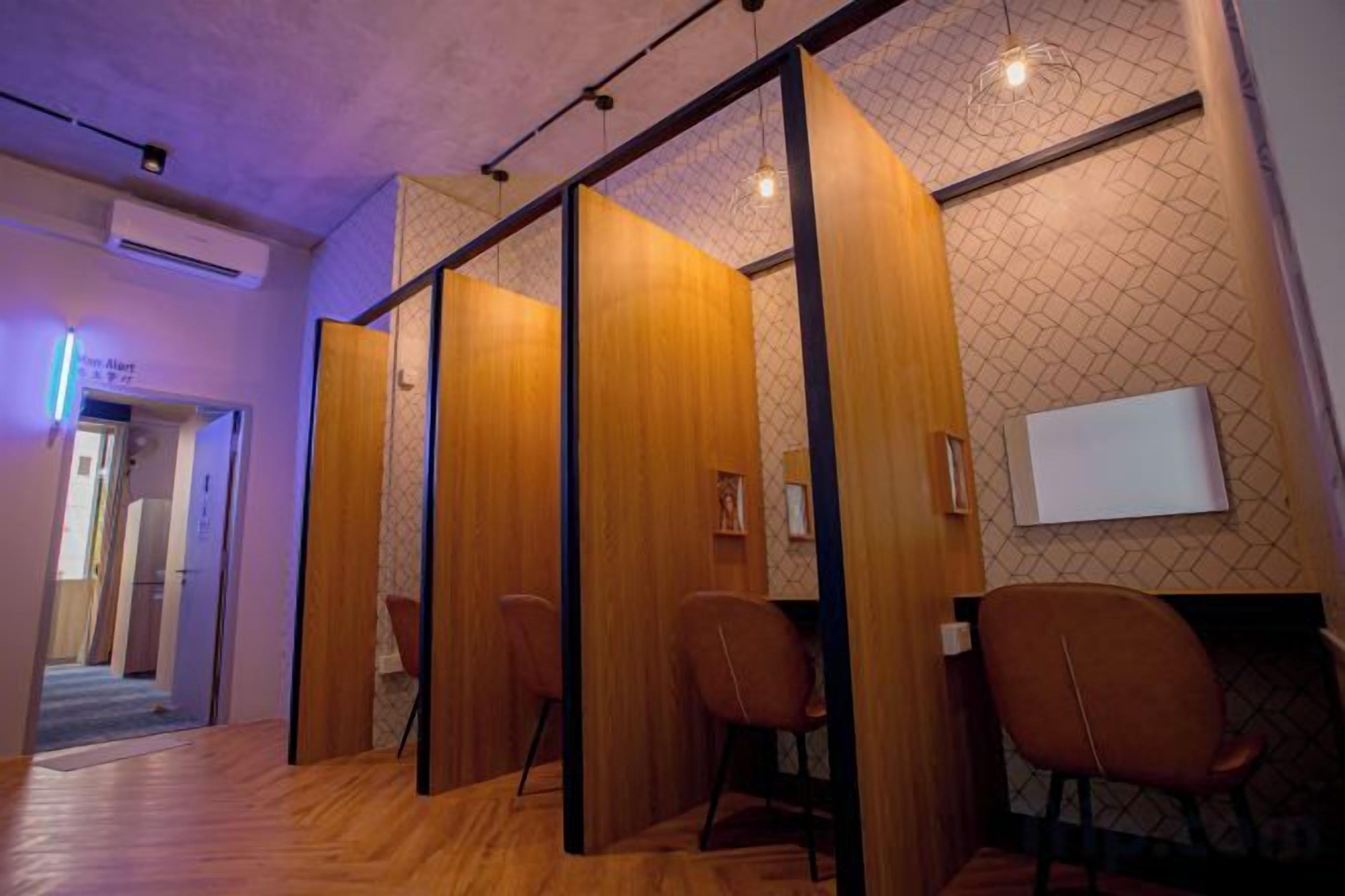 Una habitación con piso de madera, un separador con diseño geométrico y una pizarra en la pared.