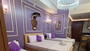 Une chambre d’hôtel avec deux lits, un petit bureau et une salle de bain.