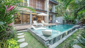 A modern house with a swimming pool, outdoor seating, and lush greenery. - Designer 5br Villa, 400m to Café Del Mar (Seminyak)