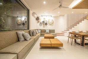 Un salon moderne avec un canapé, une table basse et un coin repas.