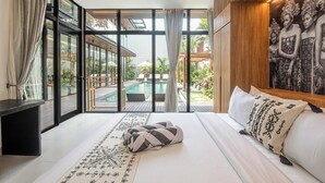 A bedroom with a large bed, a view of an outdoor pool, and a wooden ceiling. - Tropical Luxury 6BR Canggu Escape Near the Ocean (Seminyak)