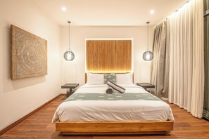 A modern bedroom with a wooden bed, two bedside tables, a large wall art piece, and a unique headboard design. - Tropical Luxury 6BR Canggu Escape Near the Ocean (Seminyak)