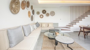 Una sala de estar moderna con sofá, mesa de centro y arte decorativo en la pared.