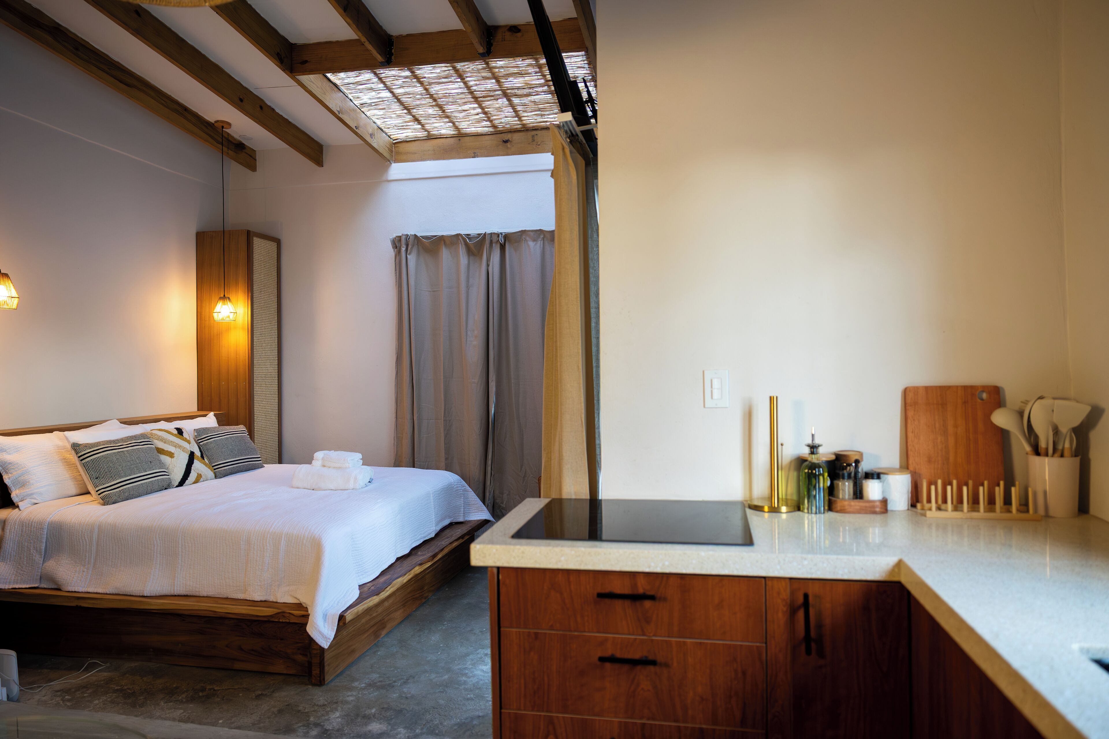 A bedroom with a wooden bed, a bedside table, and a bathroom visible through a door.