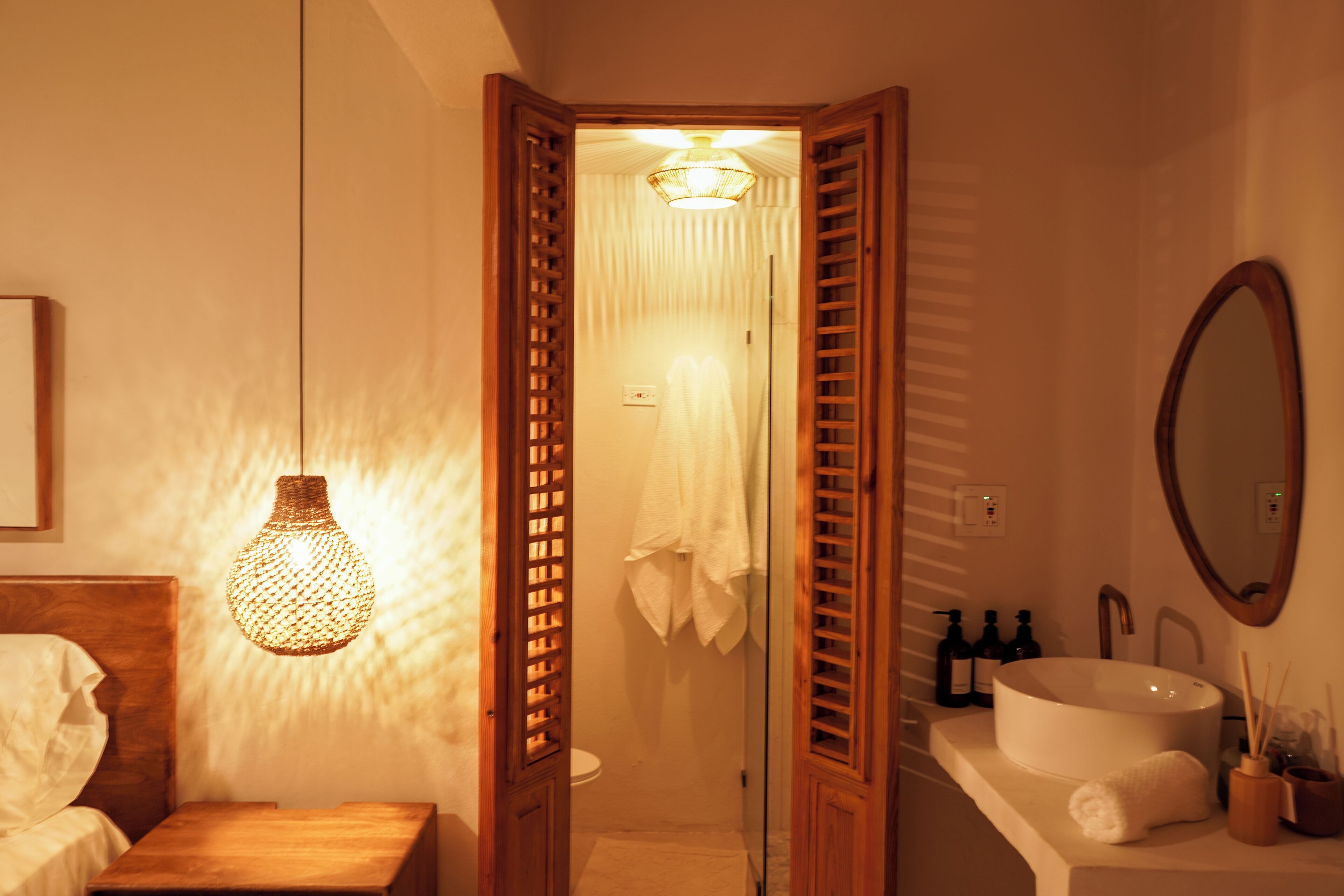 A bathroom with a wooden door, a white sink, and a mirror.