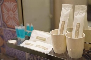 A tray with dental care items, including a cup and two packets labeled 'Dental Kit.' - Mango Inn (Semporna)