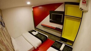 A small room with two beds, a TV, and a yellow shelf. - Mango Inn (Semporna)