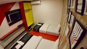 A room with two beds, a TV, a mirror, and framed pictures on the wall. - Mango Inn (Semporna)