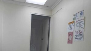 A small, clean room with a white tiled floor, a table with a red top, and two black chairs. There are signs on the wall, one of which warns against smoking and vaping. - WJV INN RAMOS (Cebu City)
