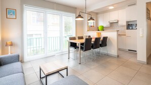 Un apartament modern amb zona de menjador, cuina i saló.