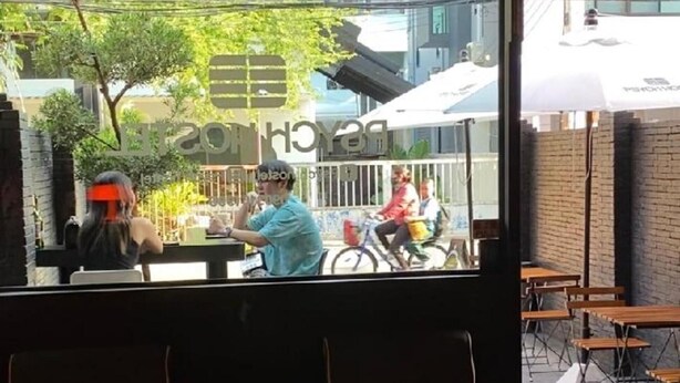 A restaurant interior with a view of the street outside. - Psych Hostel (Chiang Mai)