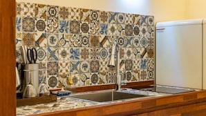 A kitchen with a tiled backsplash, two sinks, and wooden cabinets. - Dodu trophycal Pool Villa near by Airport (Jeju)