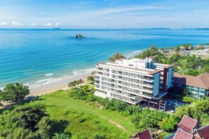 Un hotel con varios pisos, vista al mar y cielo despejado.