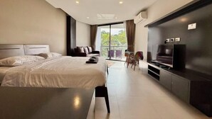 Une chambre d’hôtel moderne dotée d’un grand lit, d’une télévision à écran plat, d’un balcon avec vue et d’un coin repas.