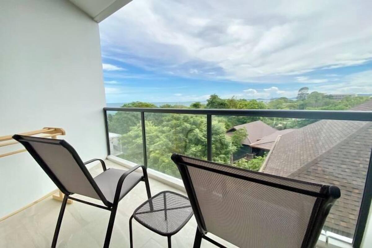 A balcony with two chairs and a view of a residential area.