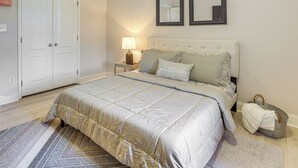 A bedroom with a bed, nightstand, lamp, and a grey woven basket. - < 4 Mi to UAB & Dtwn: Updated Birmingham Apt (Birmingham)